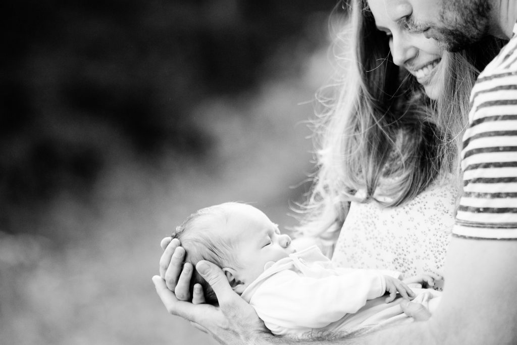 mama a otec sa usmievajú na syna počas fotenia
